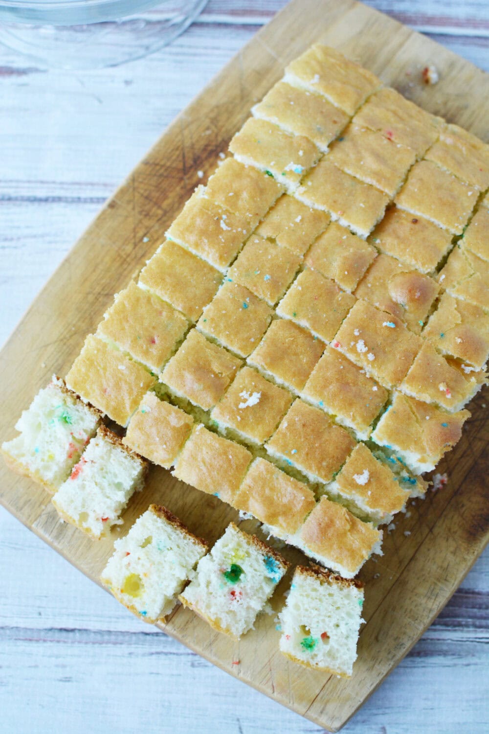 Cutting funfetti cake into cubes. 