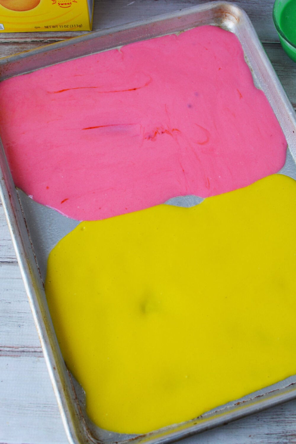 Pink and yellow cake batter in a baking pan. 