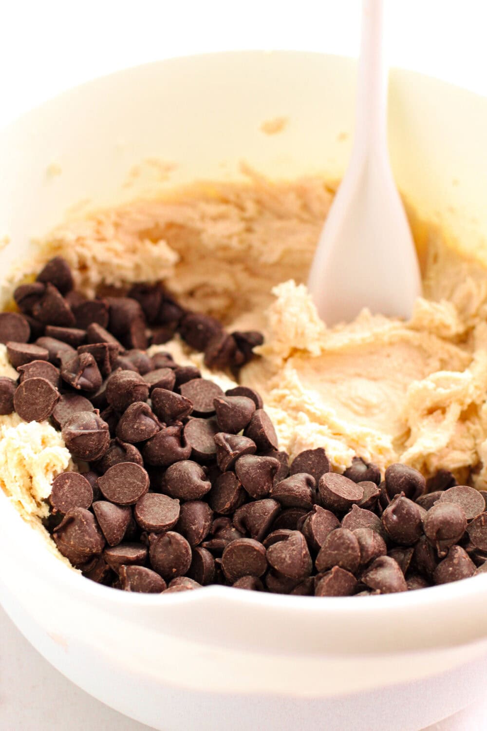 Stirring in chocolate chips to cookie batter. 