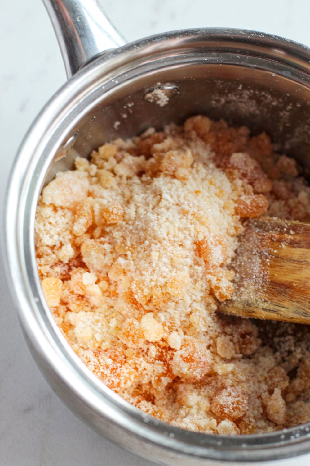 Stirring sugar in a sauce pan.