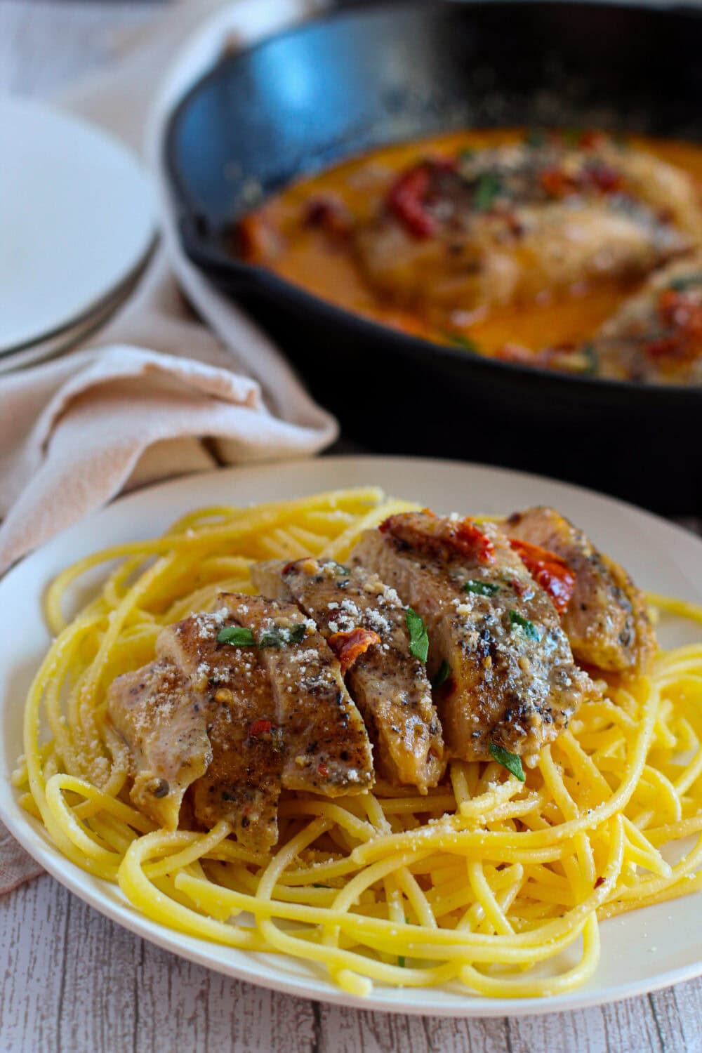 Marry me chicken over pasta on a plate.
