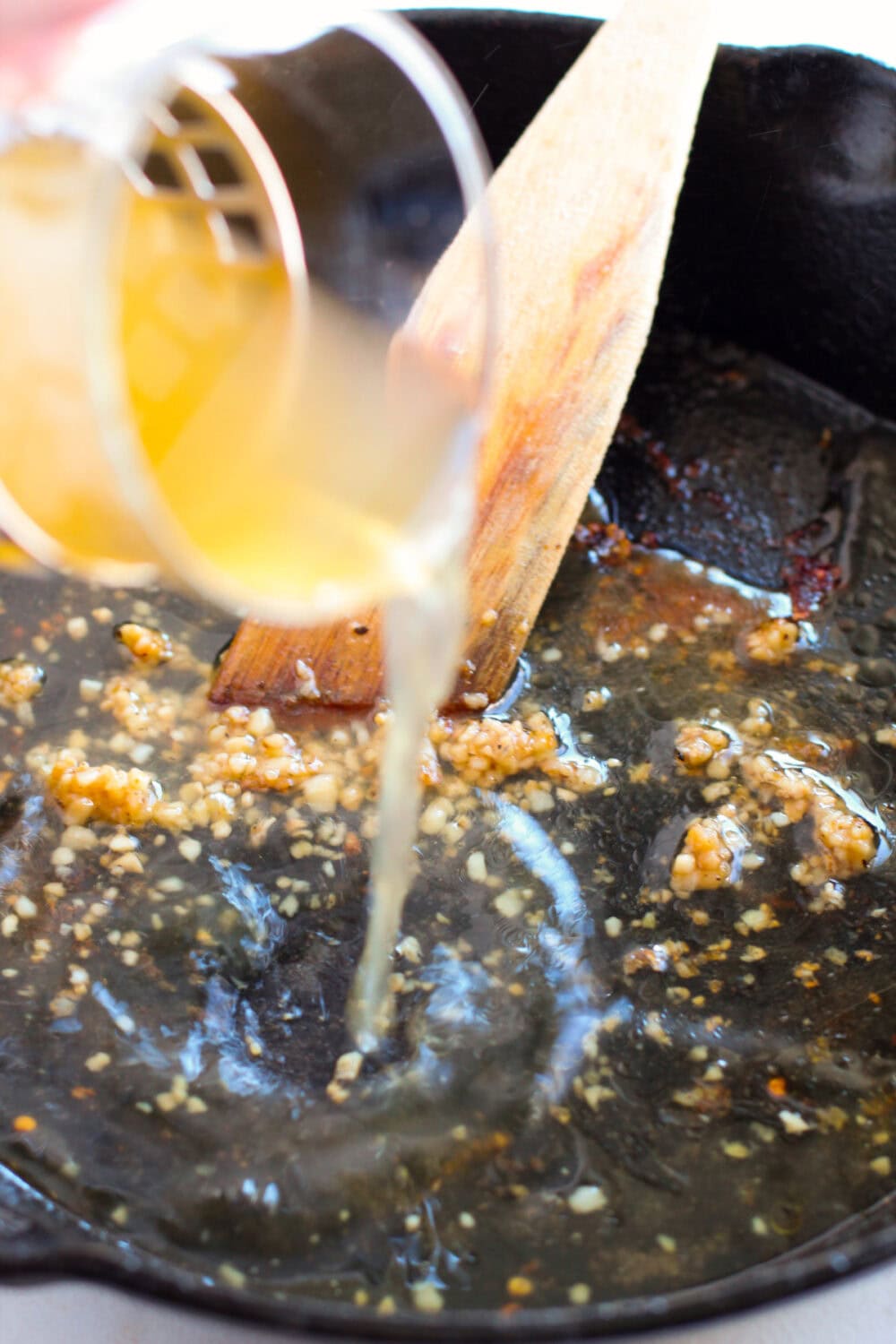 Broth and minced garlic in a skillet.