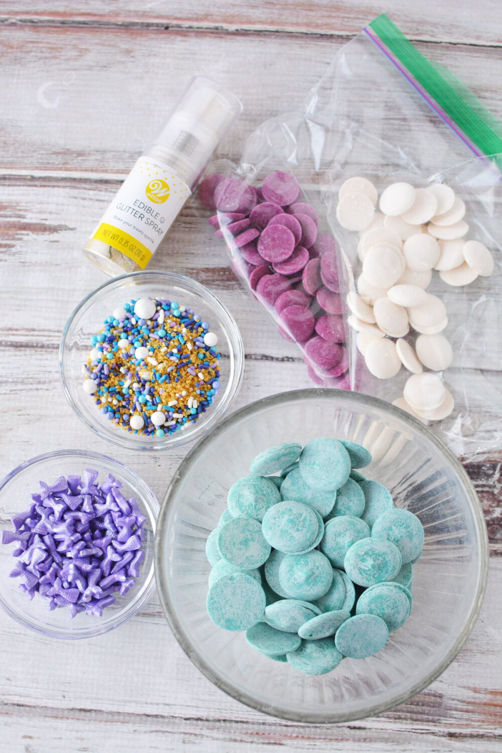 Candy melts, edible glitter, and sprinkles in bowls. 