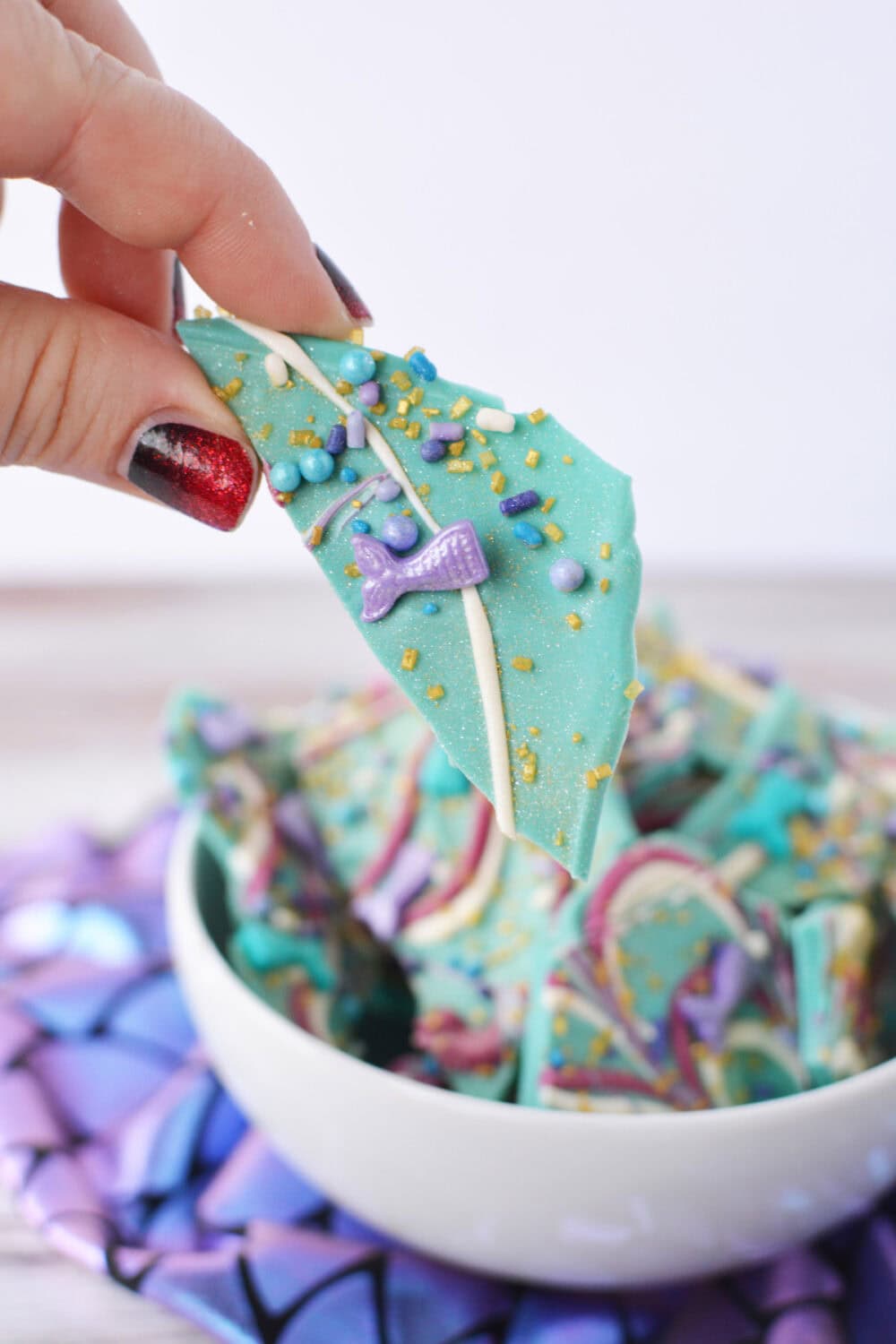 Holding a piece of mermaid bark with the bowl in the bacground.