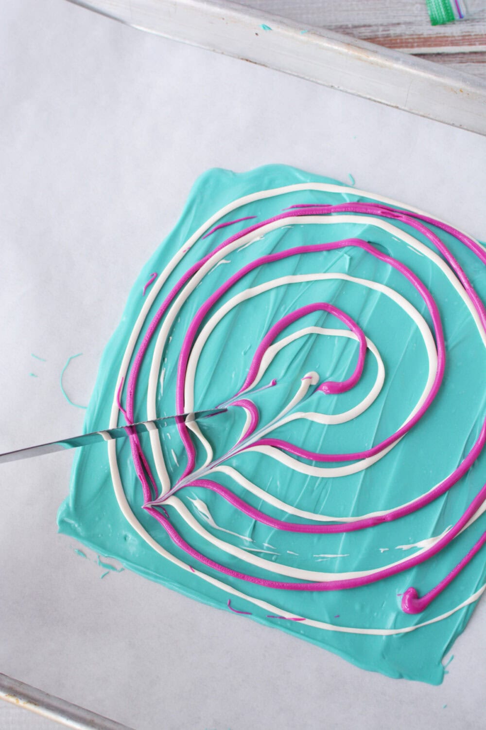Swirled purple and white candy melts on a baking sheet. 