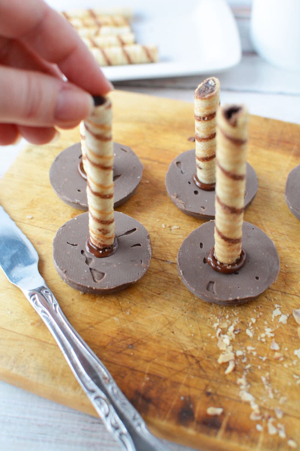 Placing wafers onto cookies to make toadstools. 