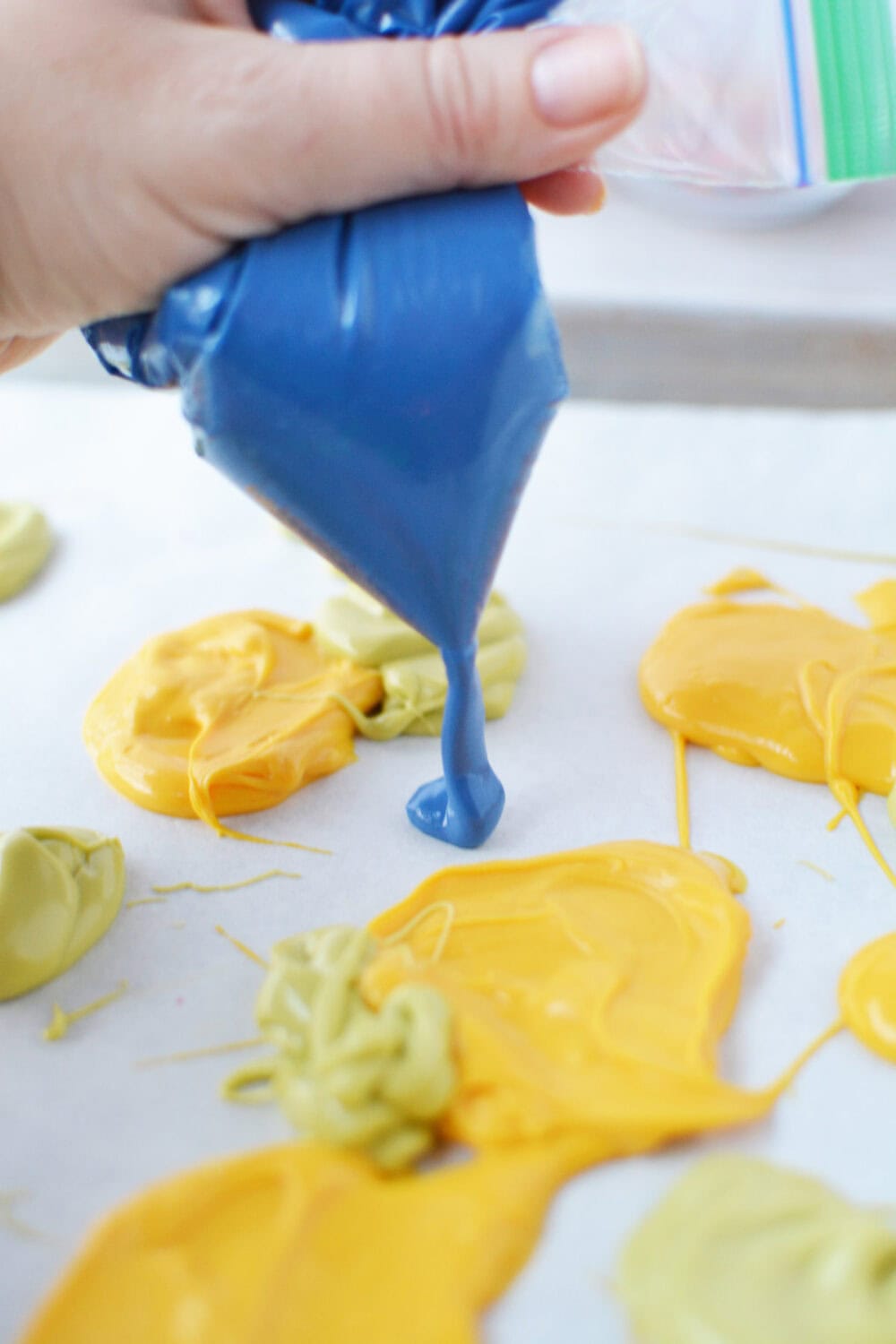 Squeezing candy melts on to a baking sheet. 