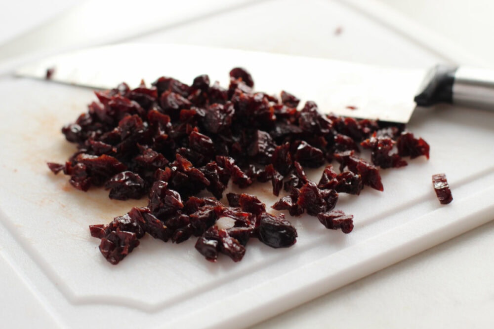 Chopping cherries on a board.