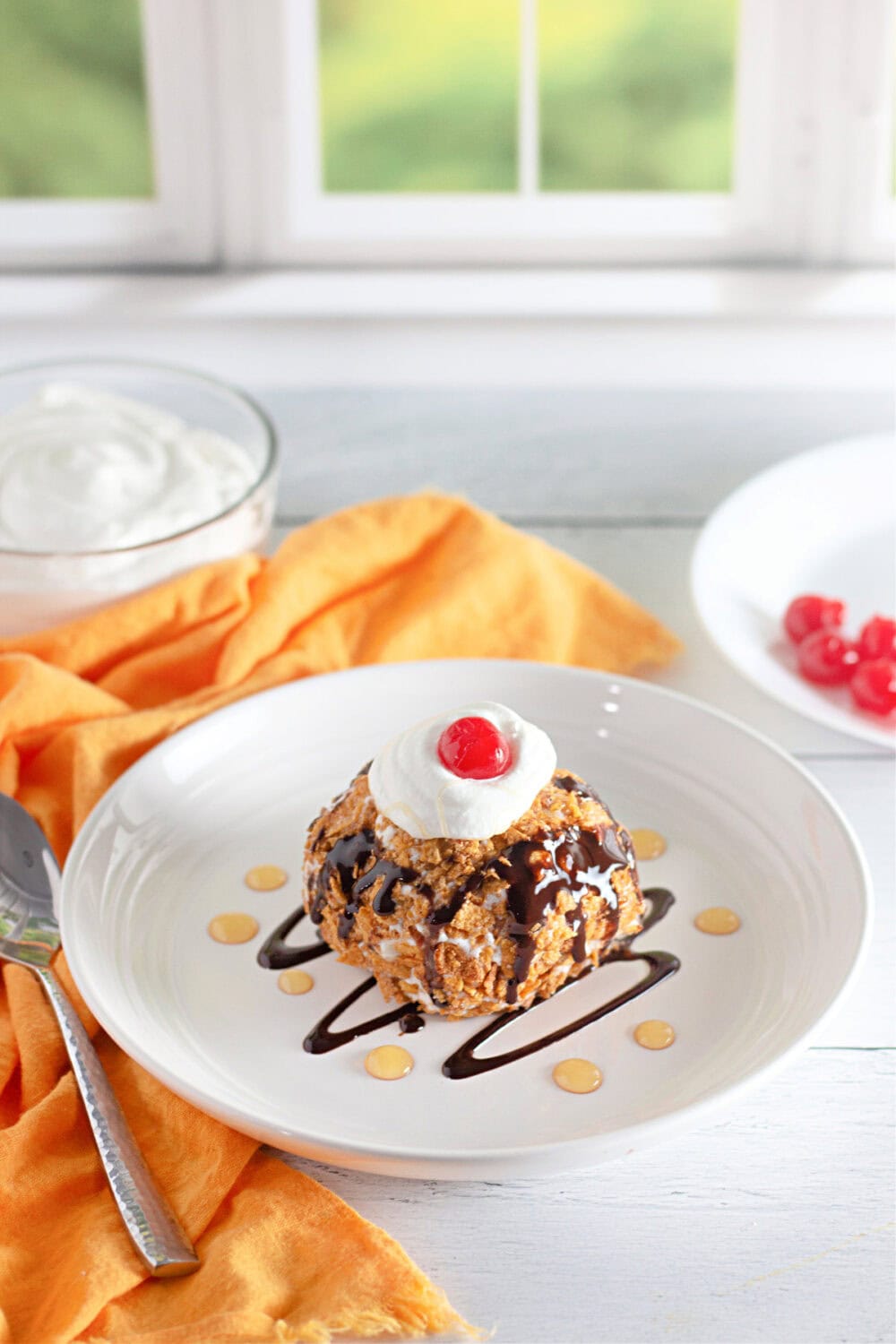 Fired ice cream with chocolate syrup and a cherry. 