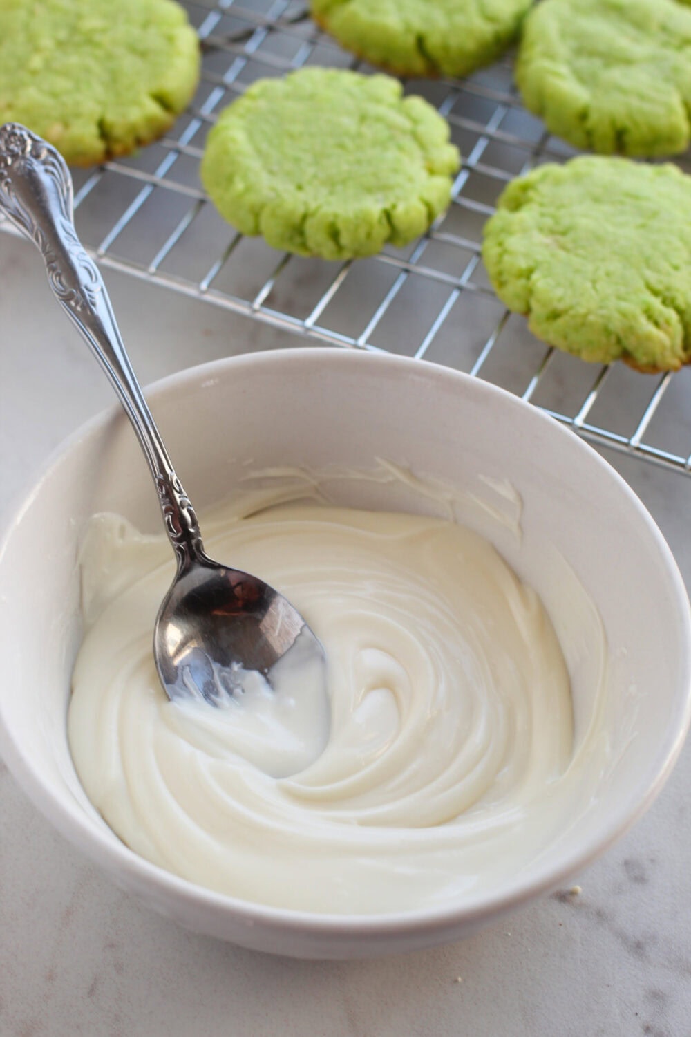 Melted white chocolate in a bowl with a spoon.
