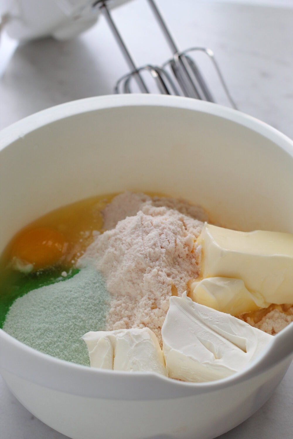 Cake mix, gelatin, butter, and cream cheese in a bowl.