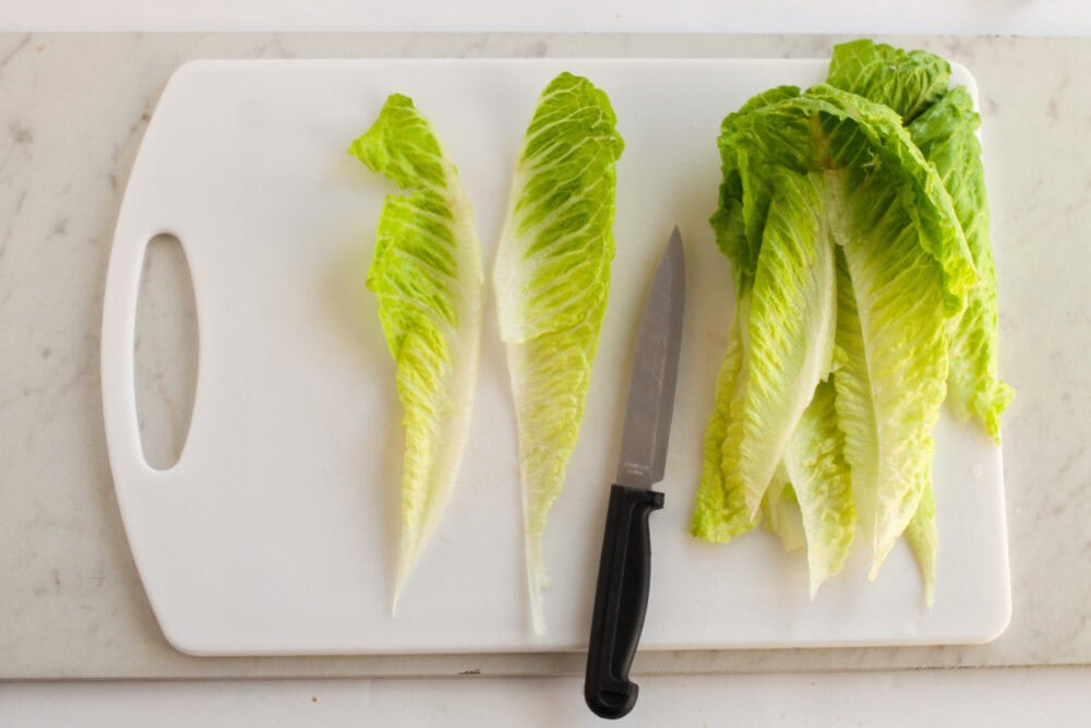 Cutting romaine lettuce on a board. 