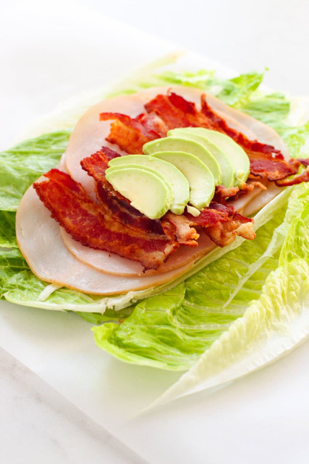 Sliced avocado on top of a turkey wrap. 