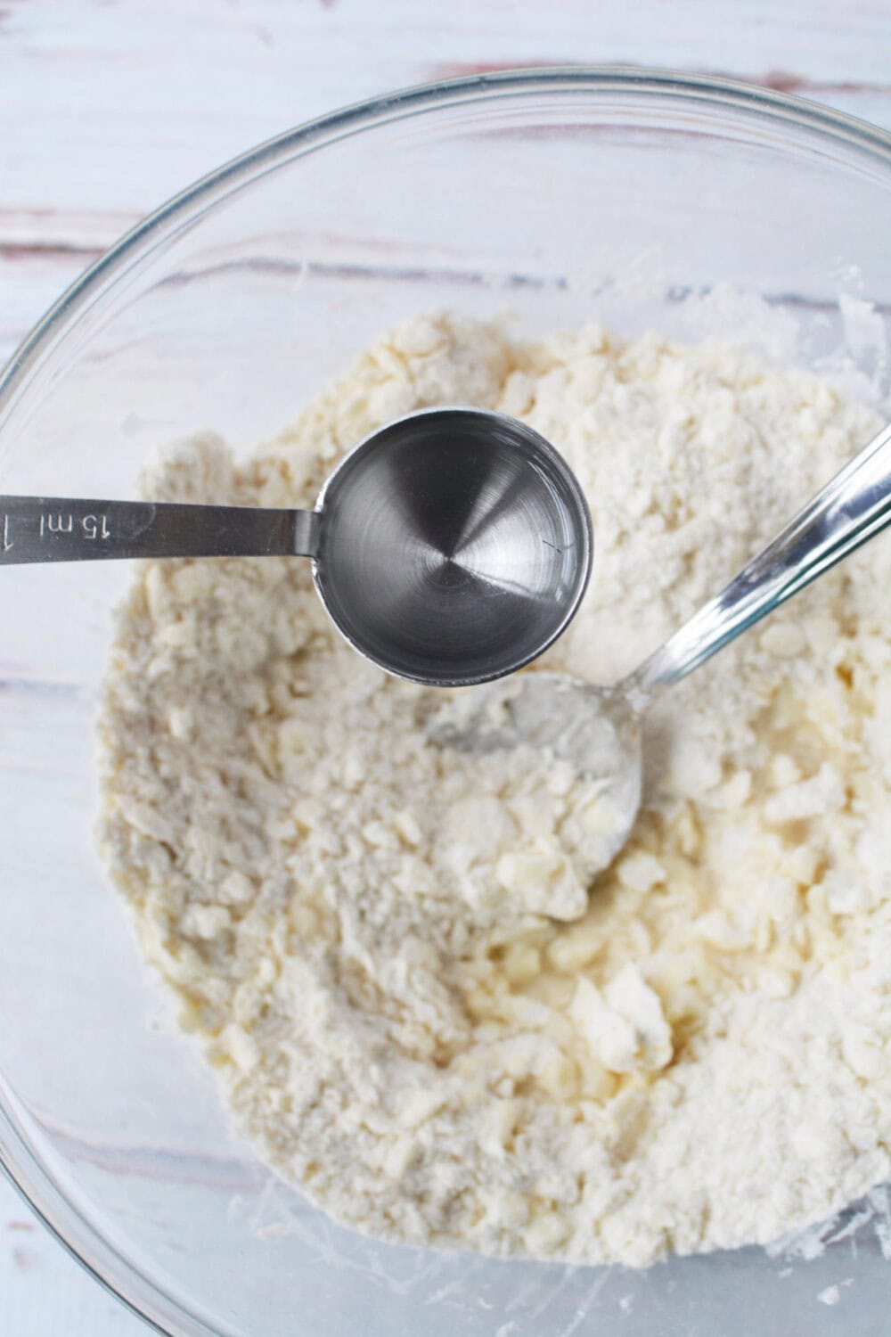 Pouring water into flour mixture. 