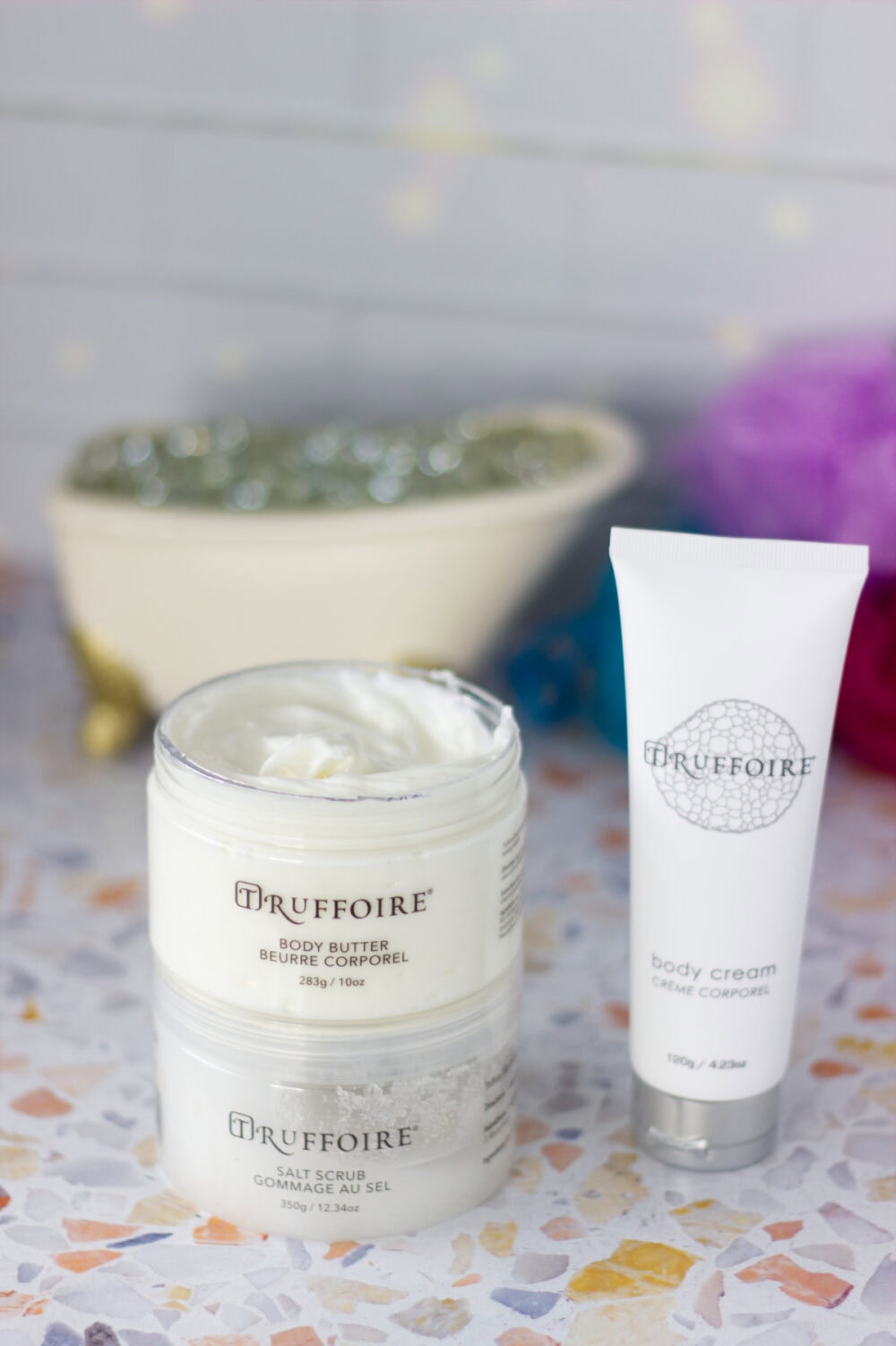 Truffoire body butter open on top of the scrub and next to the cream.