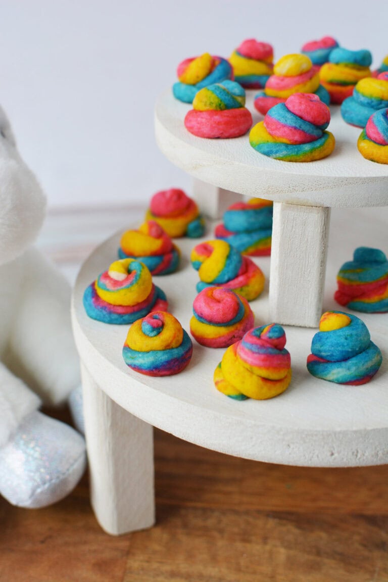 Rainbow poop unicorn shortbread cookies on a white display table.