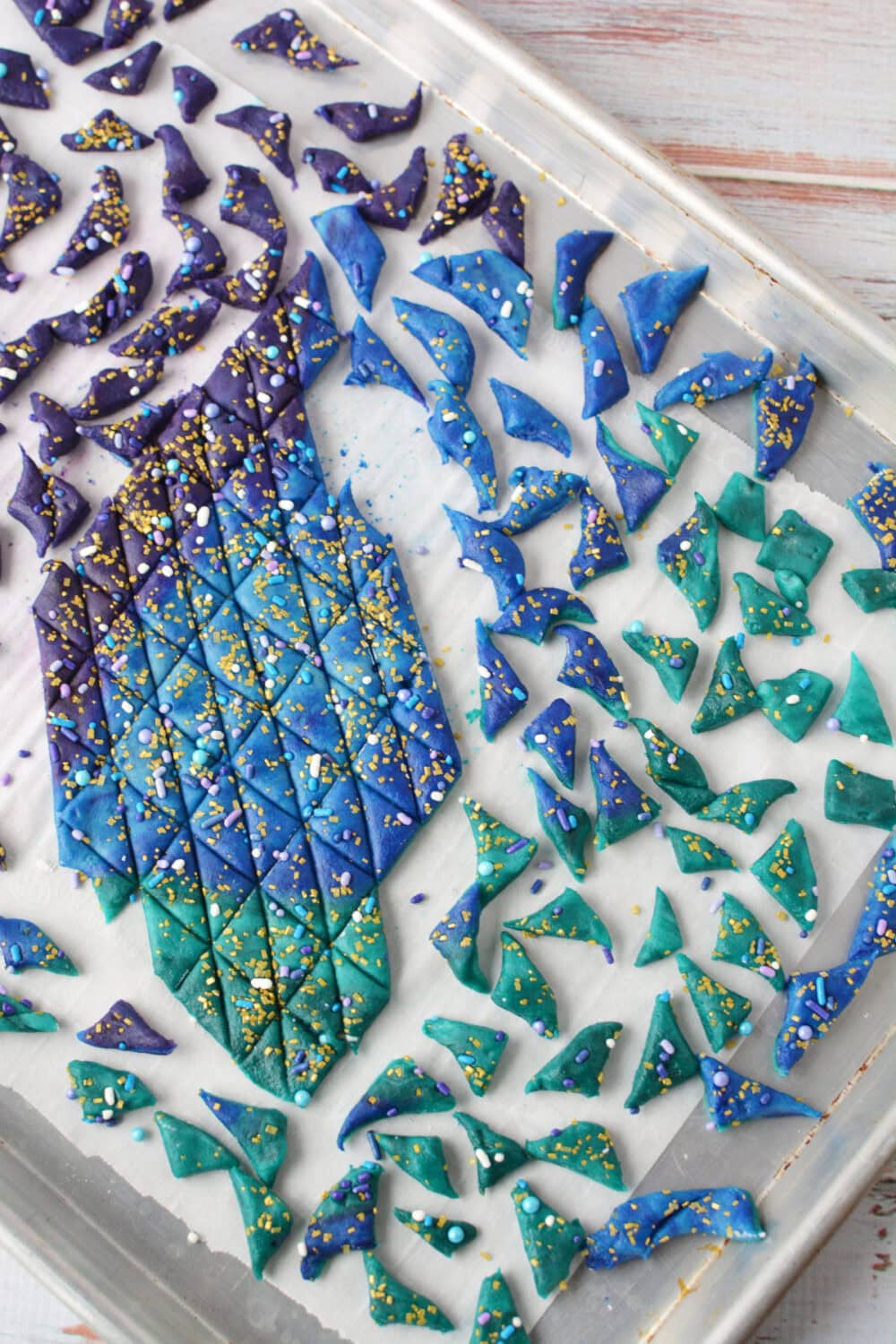 Cutting colored cookie dough into mermaid shortbread bites.