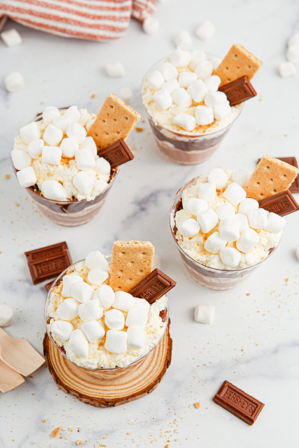 Tops of s'mores pudding cups with whipped cream, marshmallows, and graham crackers.