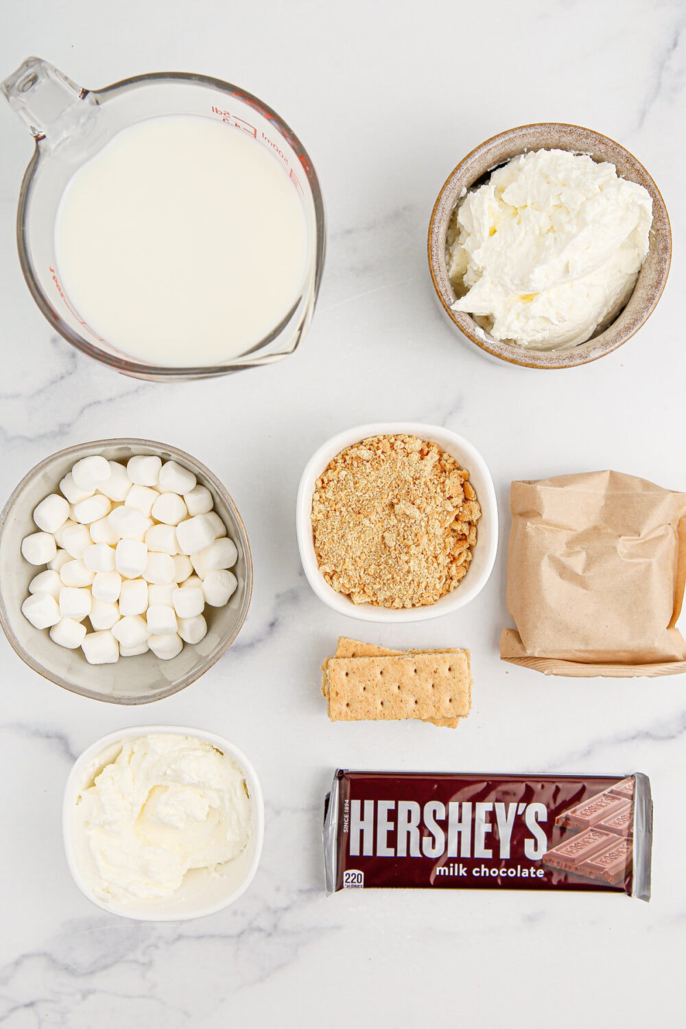 Chocolate bar, pudding mix, milk, marshmallows, whipped cream, and graham crackers.
