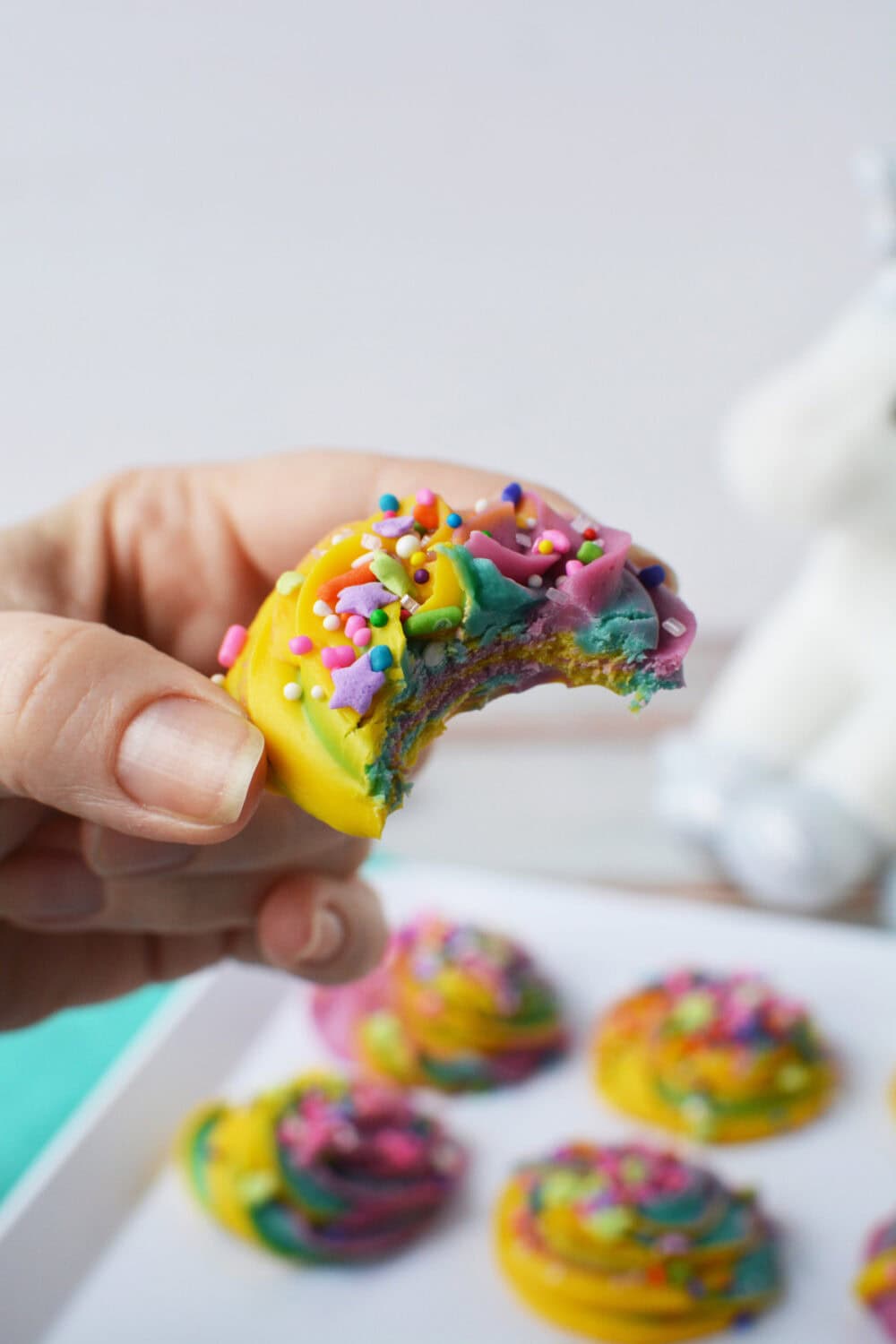 A bite taken out of a piece of swirly rainbow fudge.
