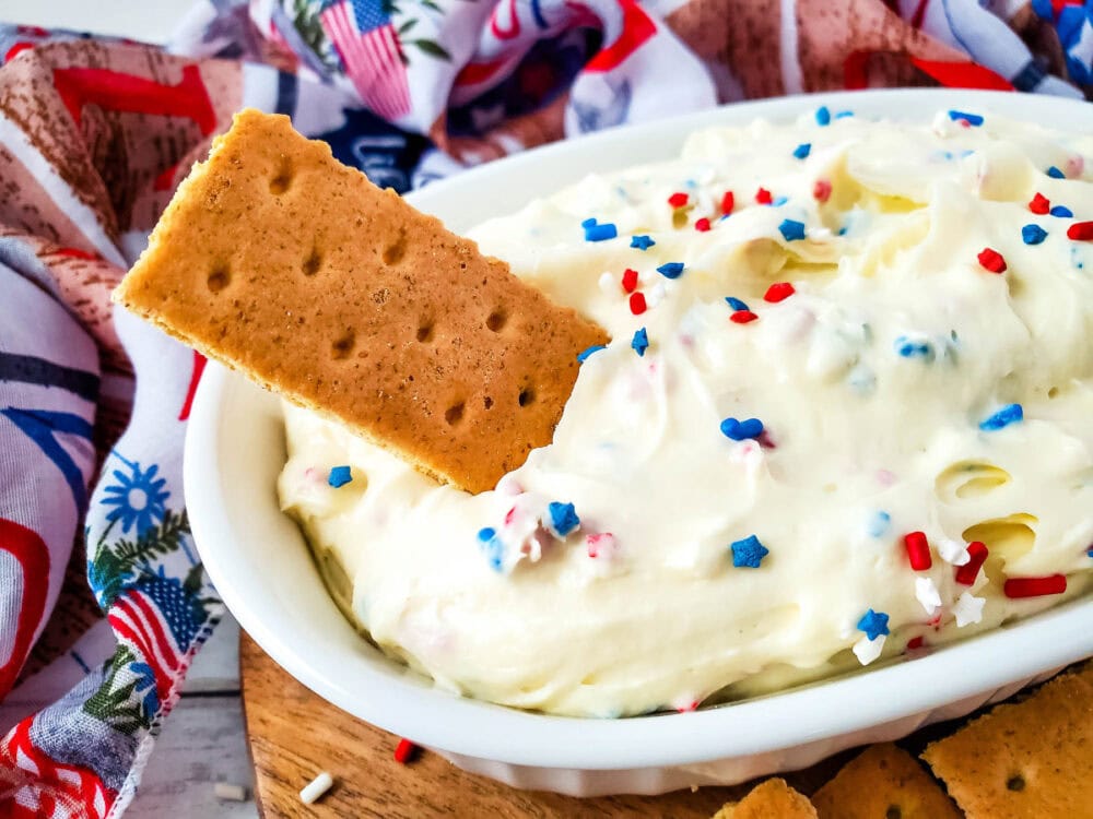 Dipping a graham cracker into cheesecake dip. 
