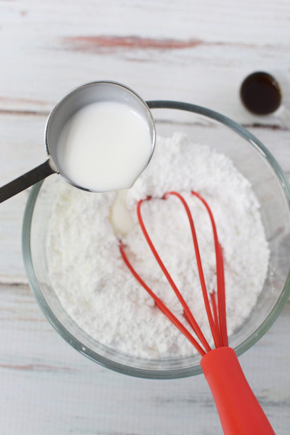 Adding milk to powdered sugar. 