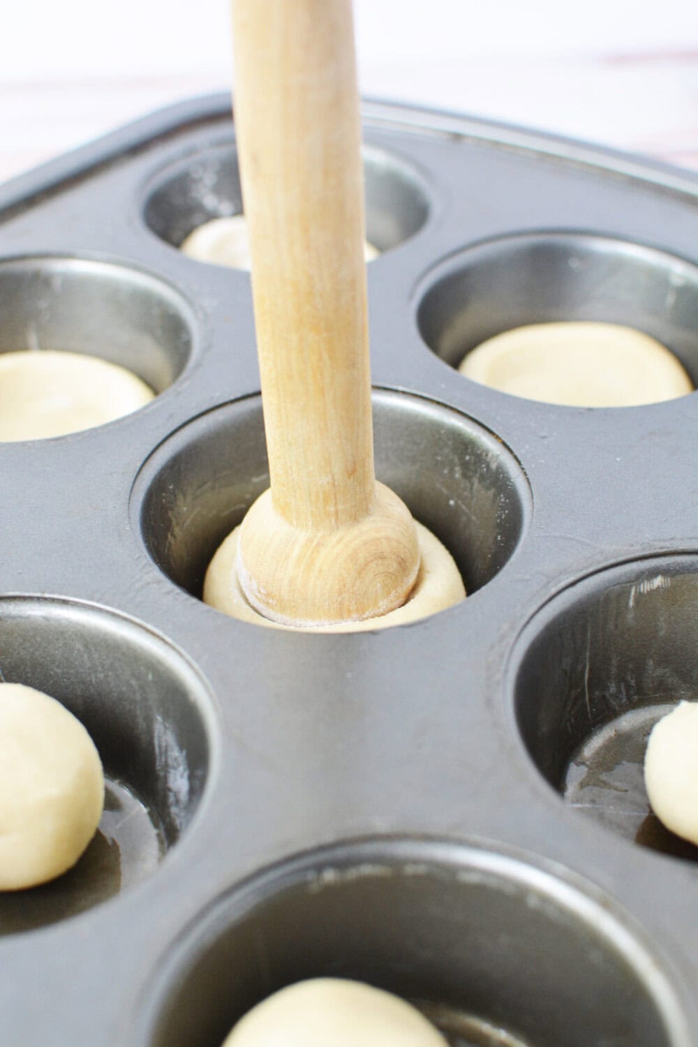 Using a tart shaper to make cookie dough into crusts. 