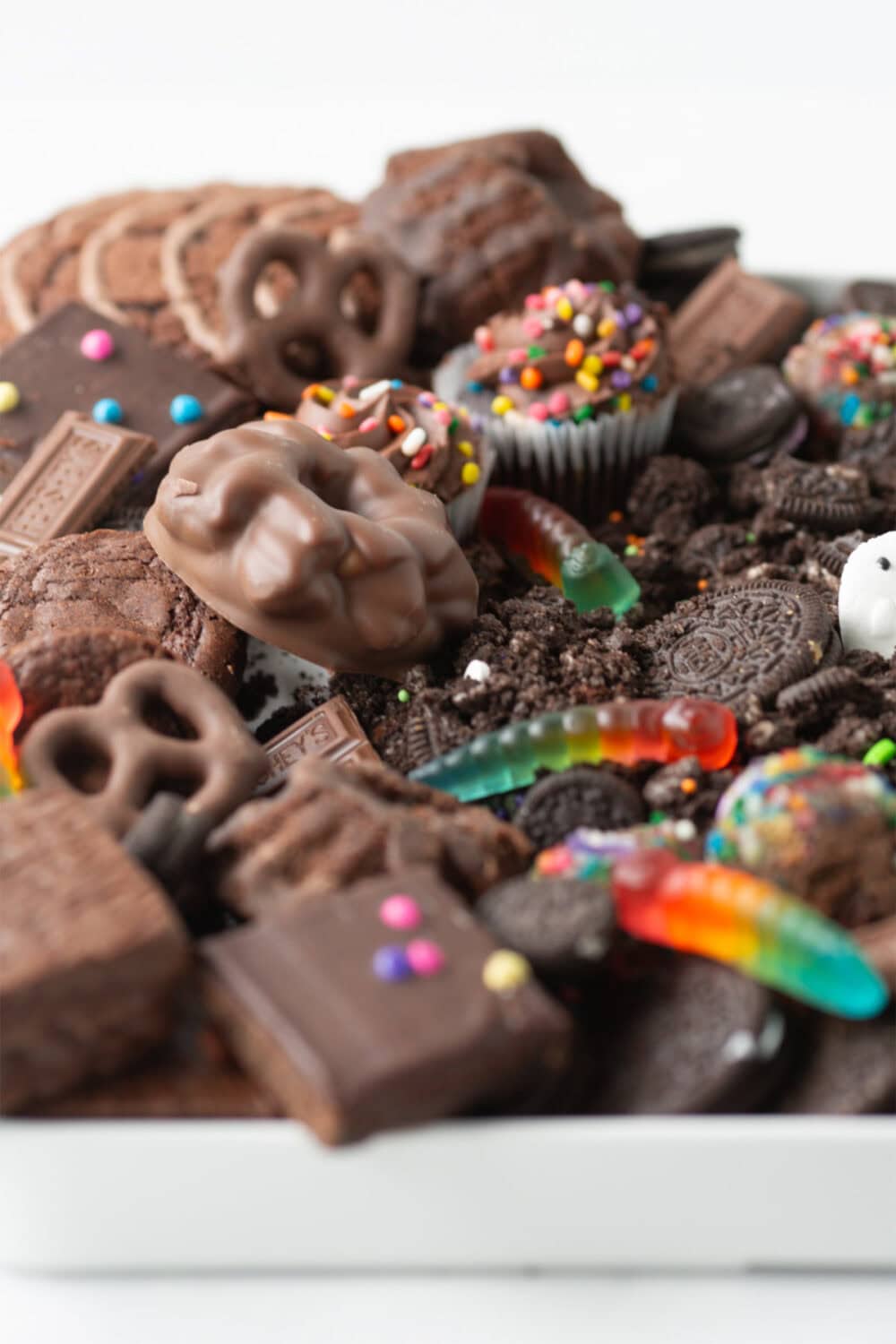 Gummy worms in the dirt and worm frosting board. 