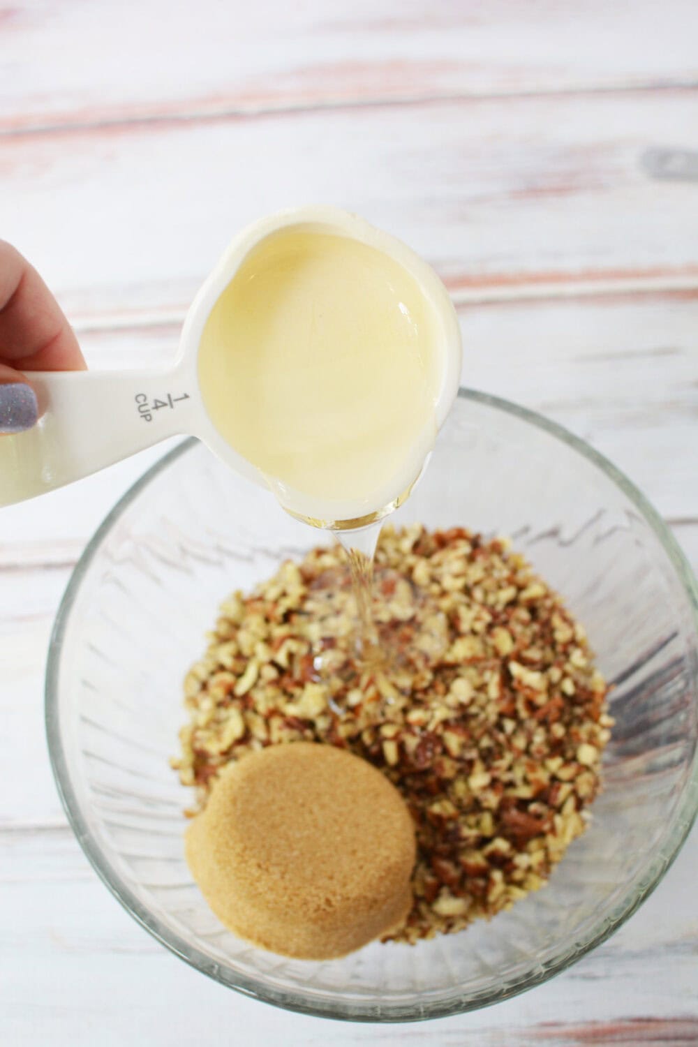 Pouring corn syrup into pecans. 