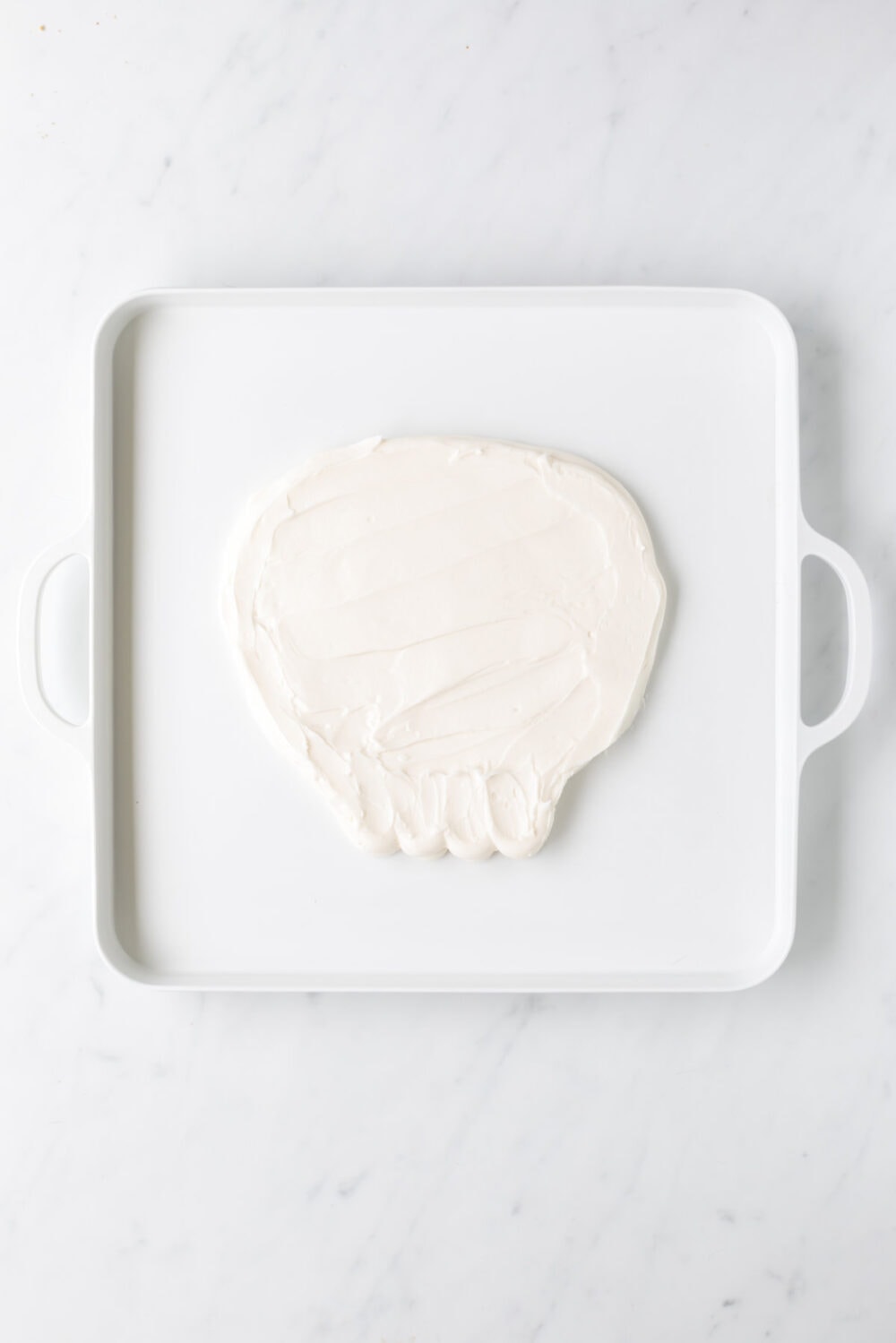 Smoothed out white frosting in the shape of a skull. 