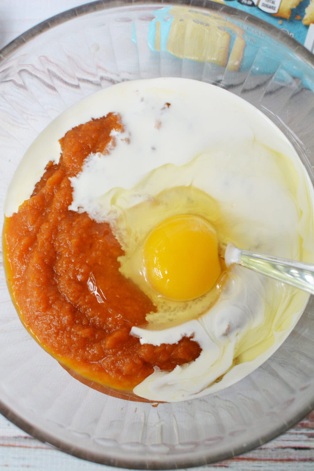 Egg being mixed into pumpkin pie filling. 