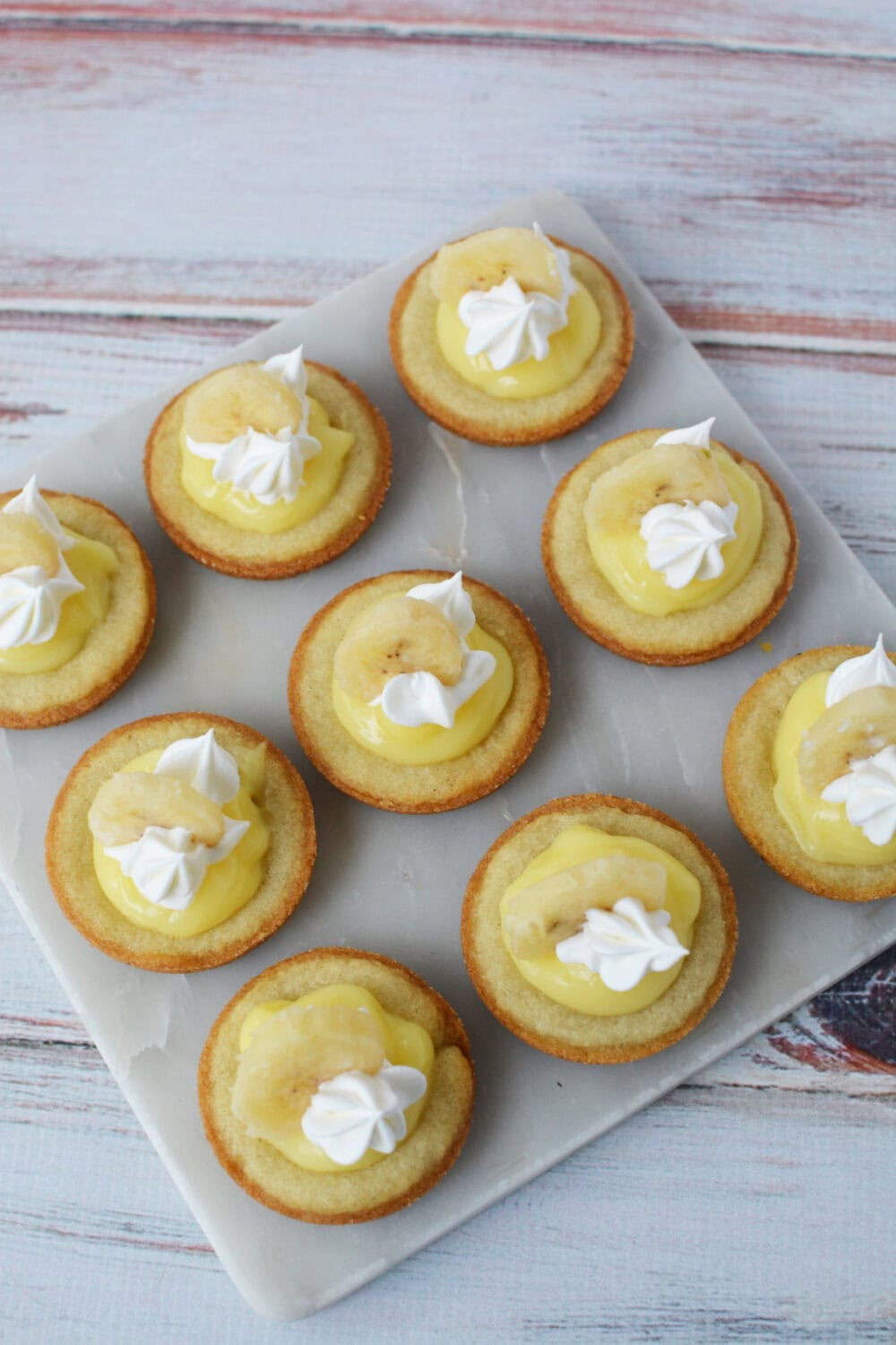 Overhead image of banana cream pie cookies on a board. 