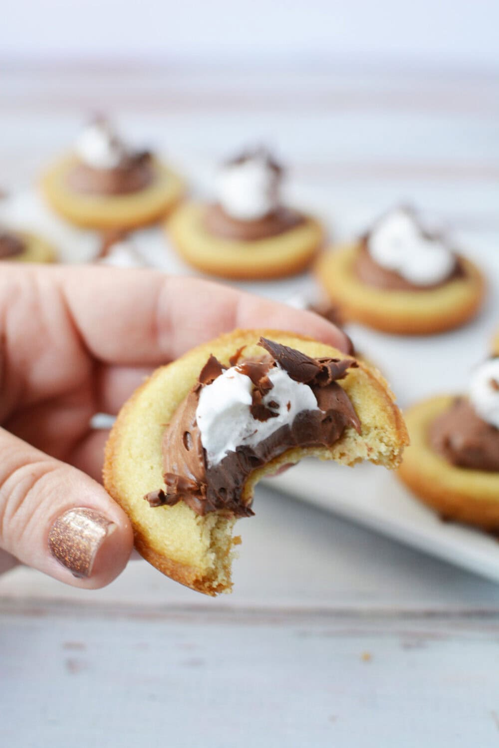 Holding a French silk pie cookie with a bite taken out of it. 
