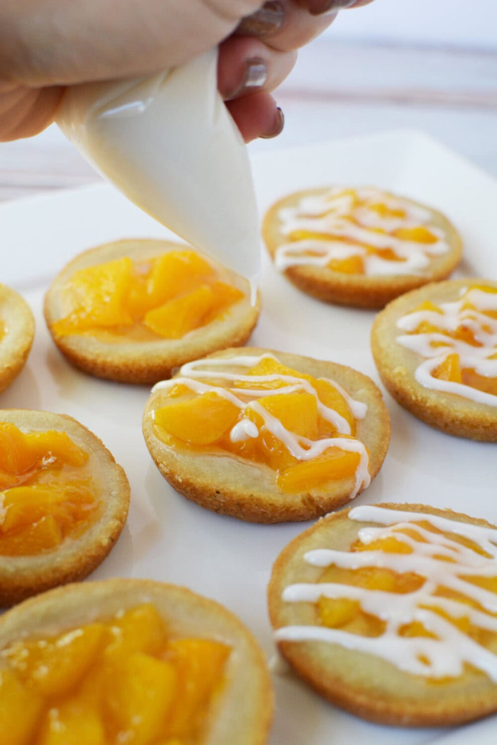 Icing peach pie cookies.
