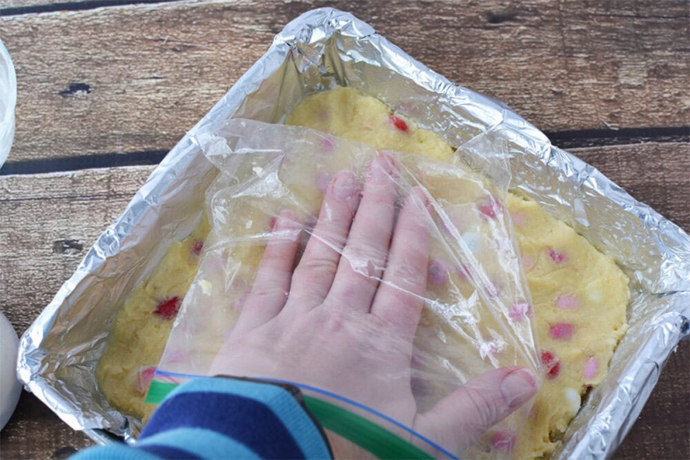 Patting down cookie dough with a bag on my hand.