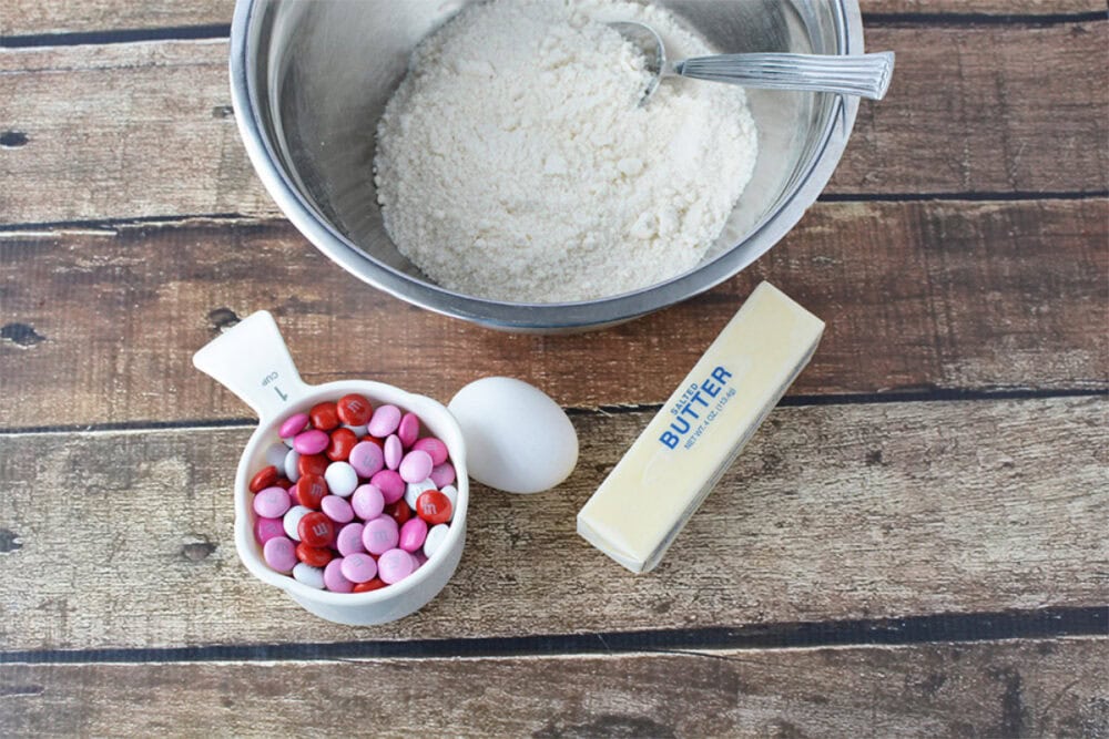 Sugar cookie mix, red, pink, and white candies, egg, and butter. 