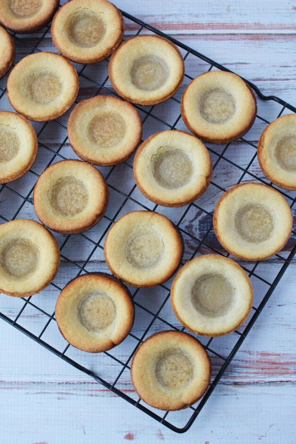 Sugar cookie pie crusts cooling on a wire rack. 