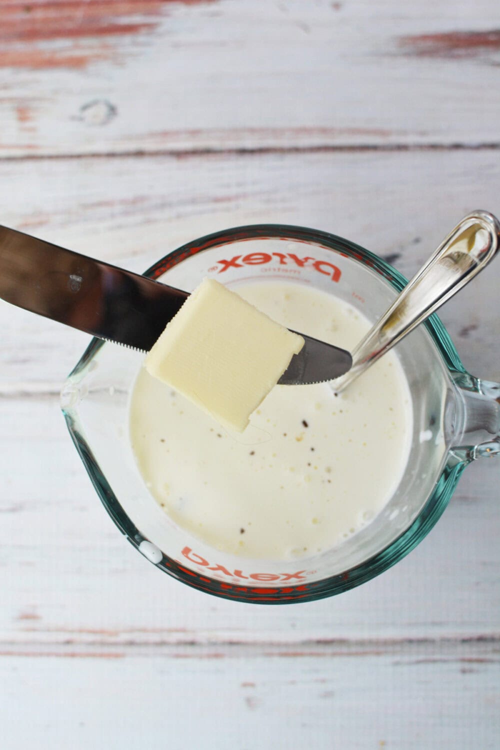 Adding butter to measuring cup.