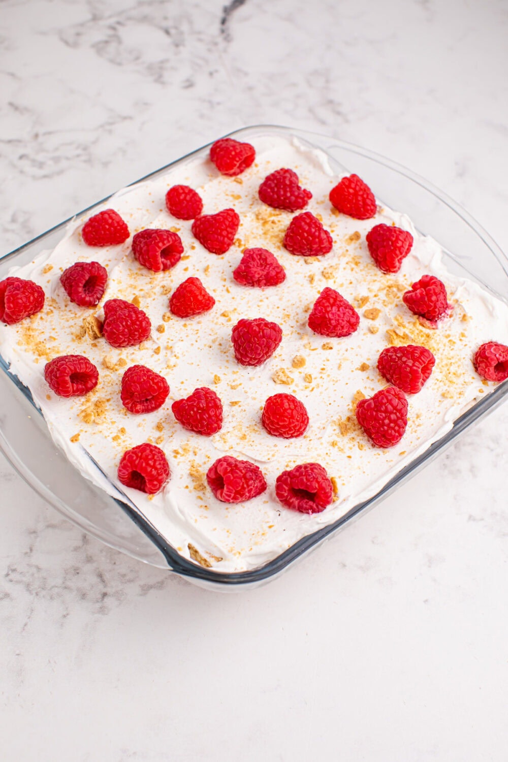 Fresh raspberries and graham cracker crumbles on top of raspberry cream icebox cake.