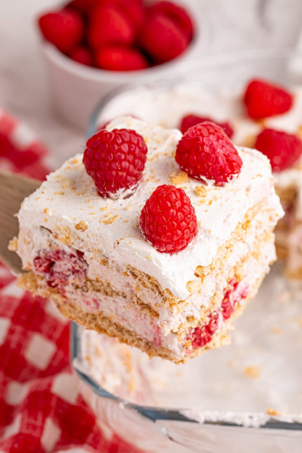 Top of a slice of a raspberry cream icebox cake as it's being lifted out of the pan.