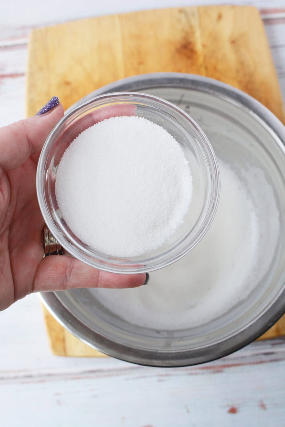 Adding sugar to whipped egg whites. 
