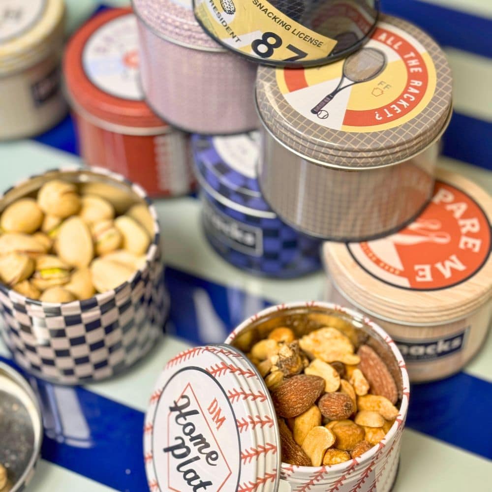 Nut and snack mixes in tins on a bar cart.
