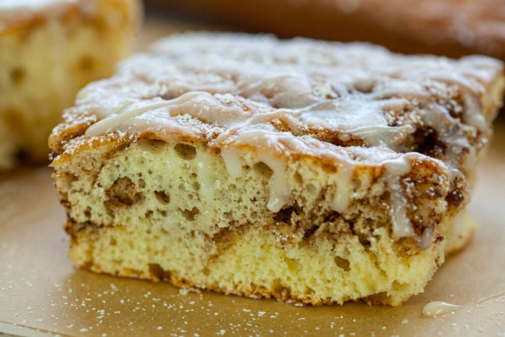 Cinnamon roll cake topped with glaze.
