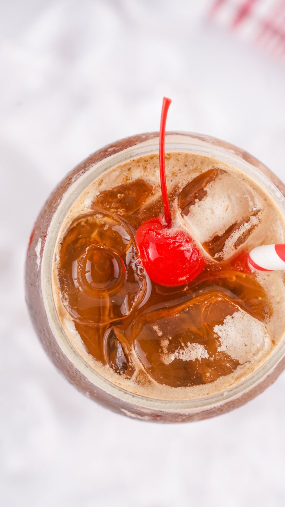Overhead shot of a glass of Fluffy Coke with a cherry on top.