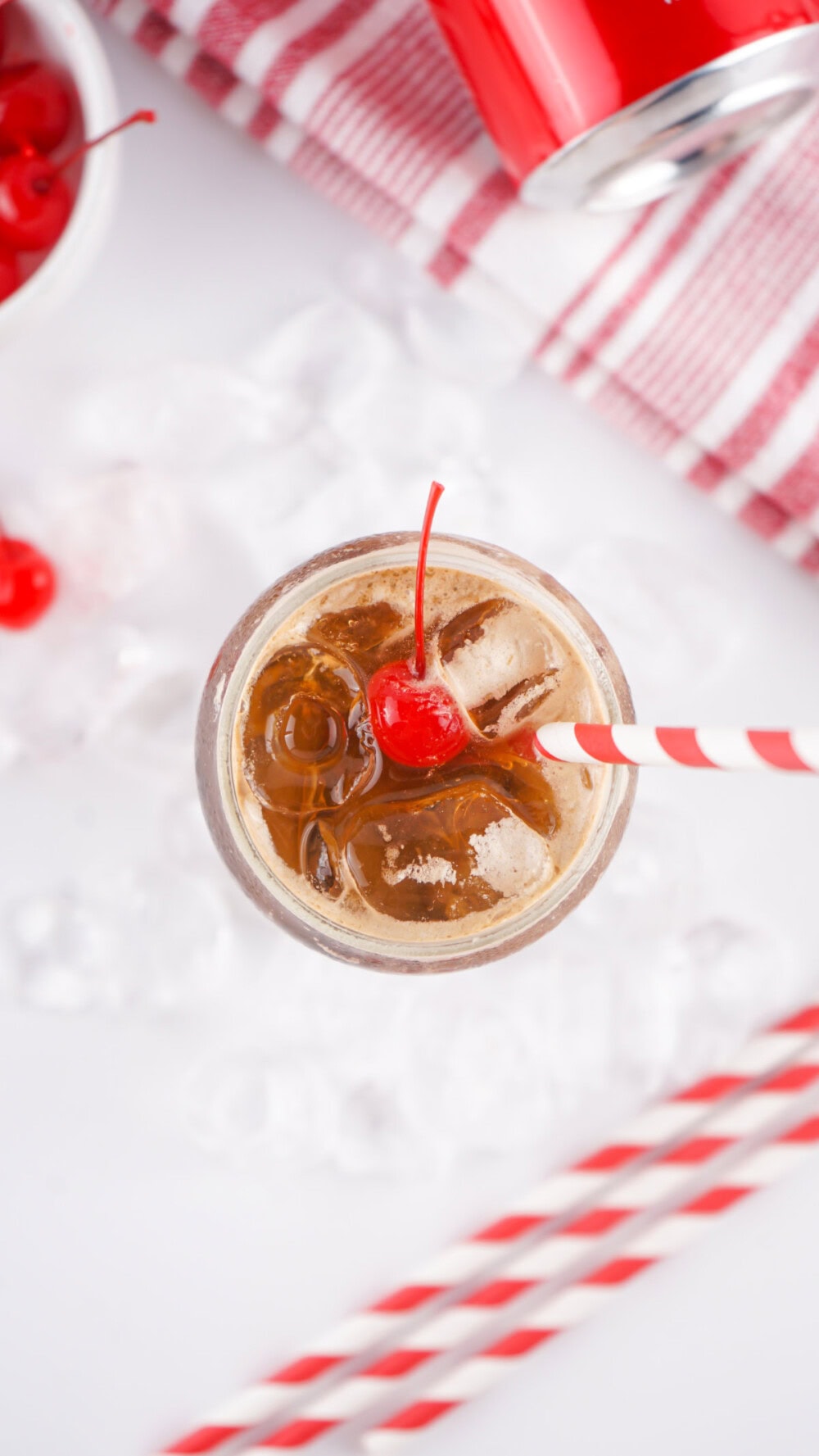 Looking down at a glass of Fluffy Coke with a cherry on top.