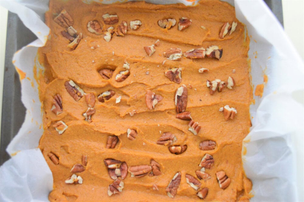 Pumpkin peanut butter fudge in the pan topped with chopped pecans.