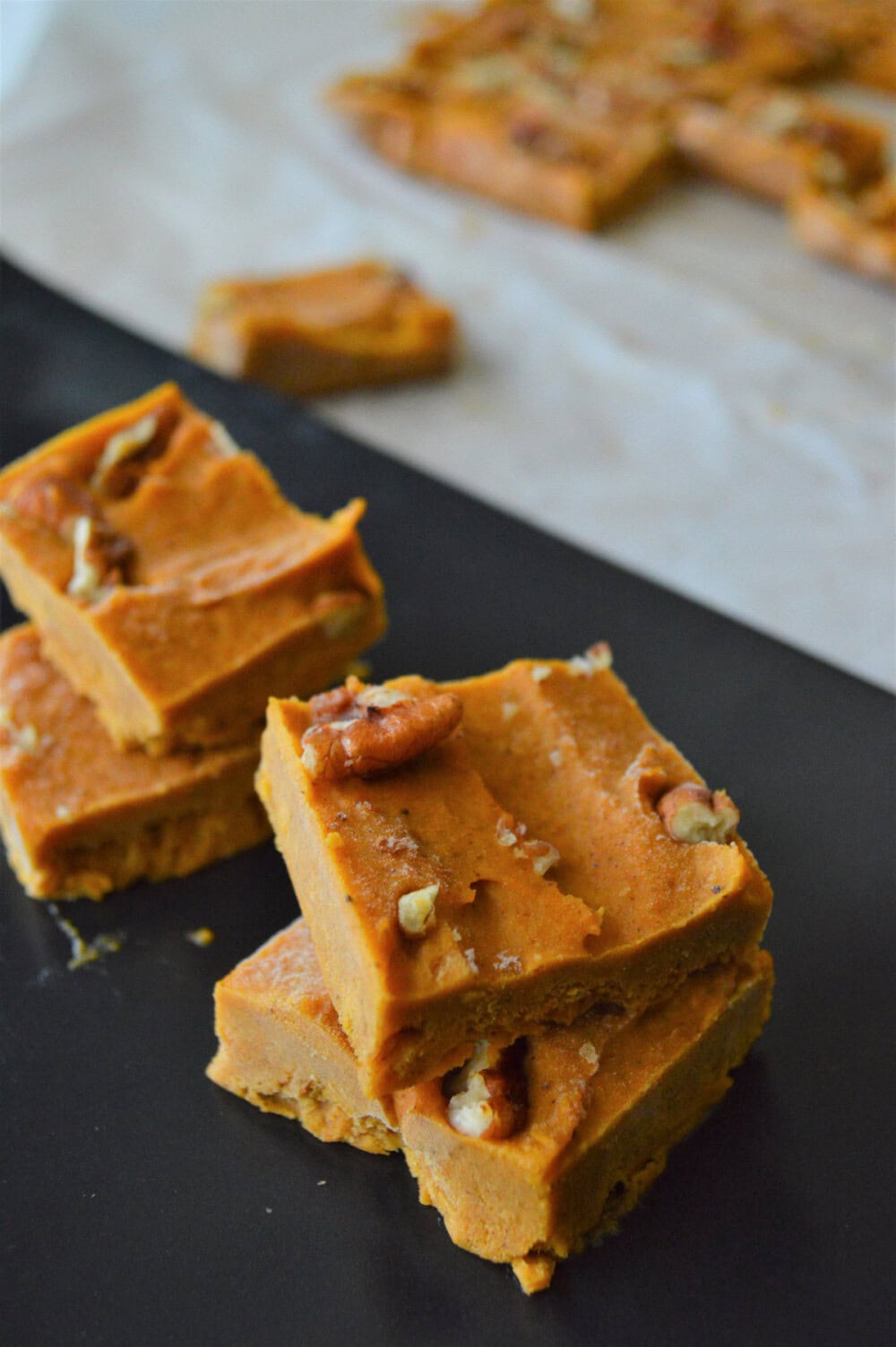 Slices of peanut butter fudge topped with pecans.