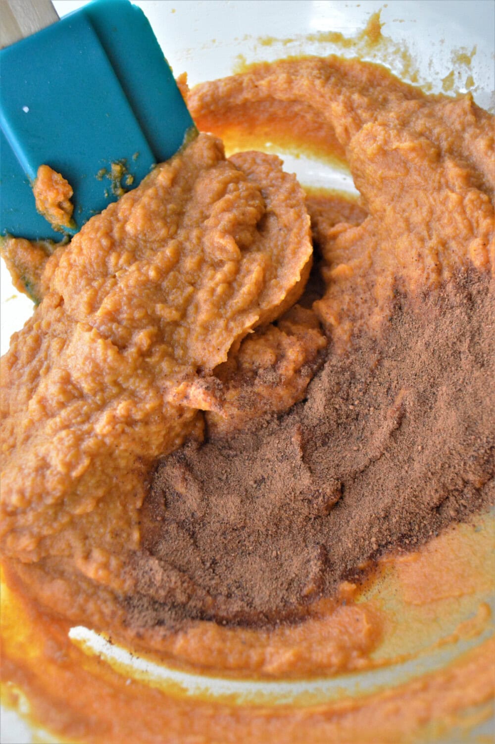 Mixing peanut butter, pumpkin and other wet ingredients.