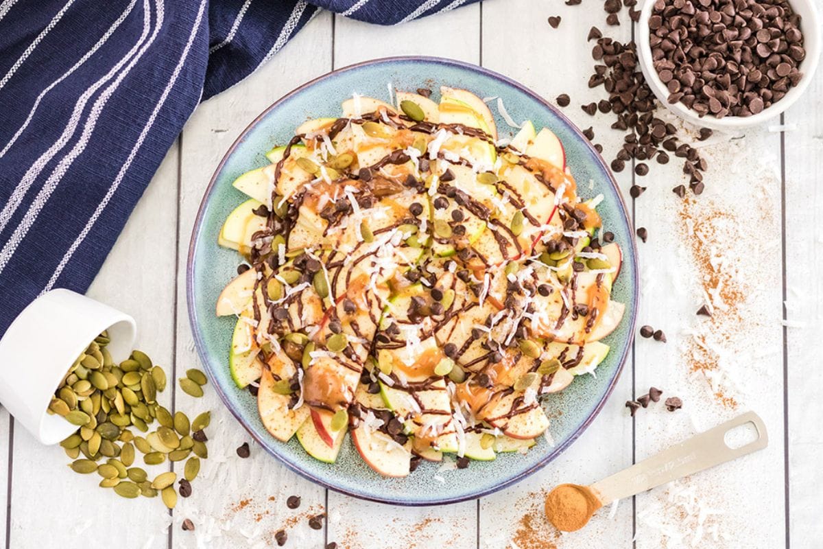 Apple nachos with toppings on a plate.