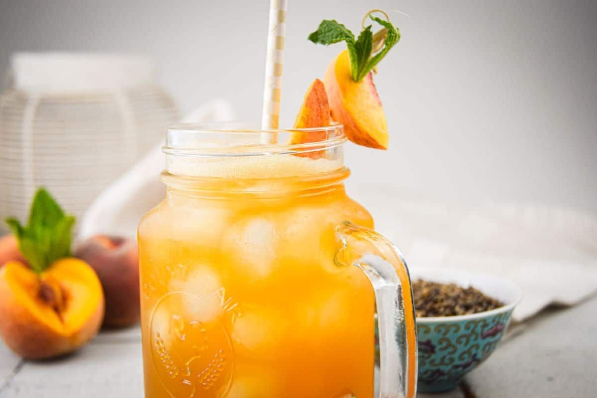 Iced peach green tea in a glass with ice.